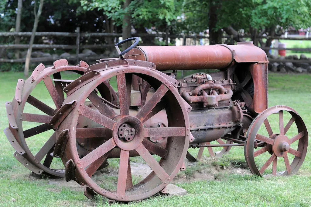An antique tractor in a field. 